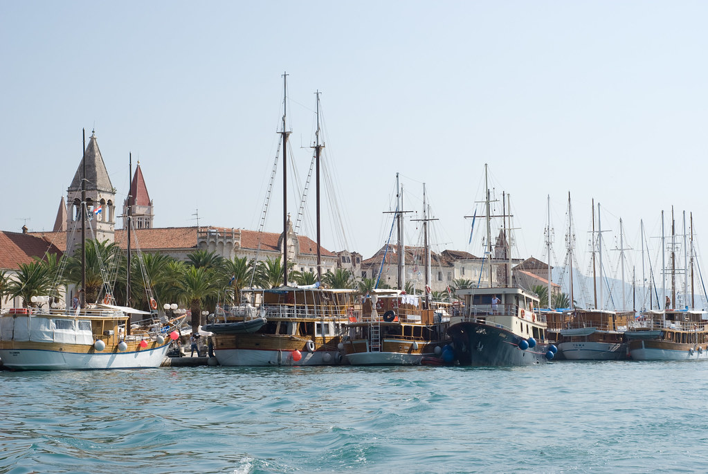 Rows of modern charter yachts berthed at a fully equipped marina base in Croatia during golden hour
